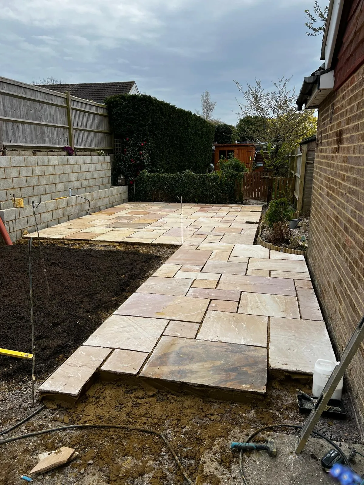 Natural stone patio with concrete block retaining wall in Kent