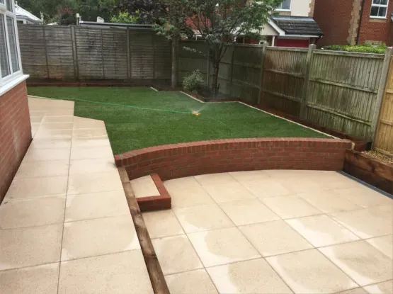 Patio with artificial turf and raised beds in Kent